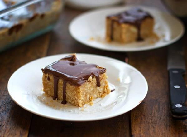 Peanut butter fudge with chocolate drizzle on a plate.