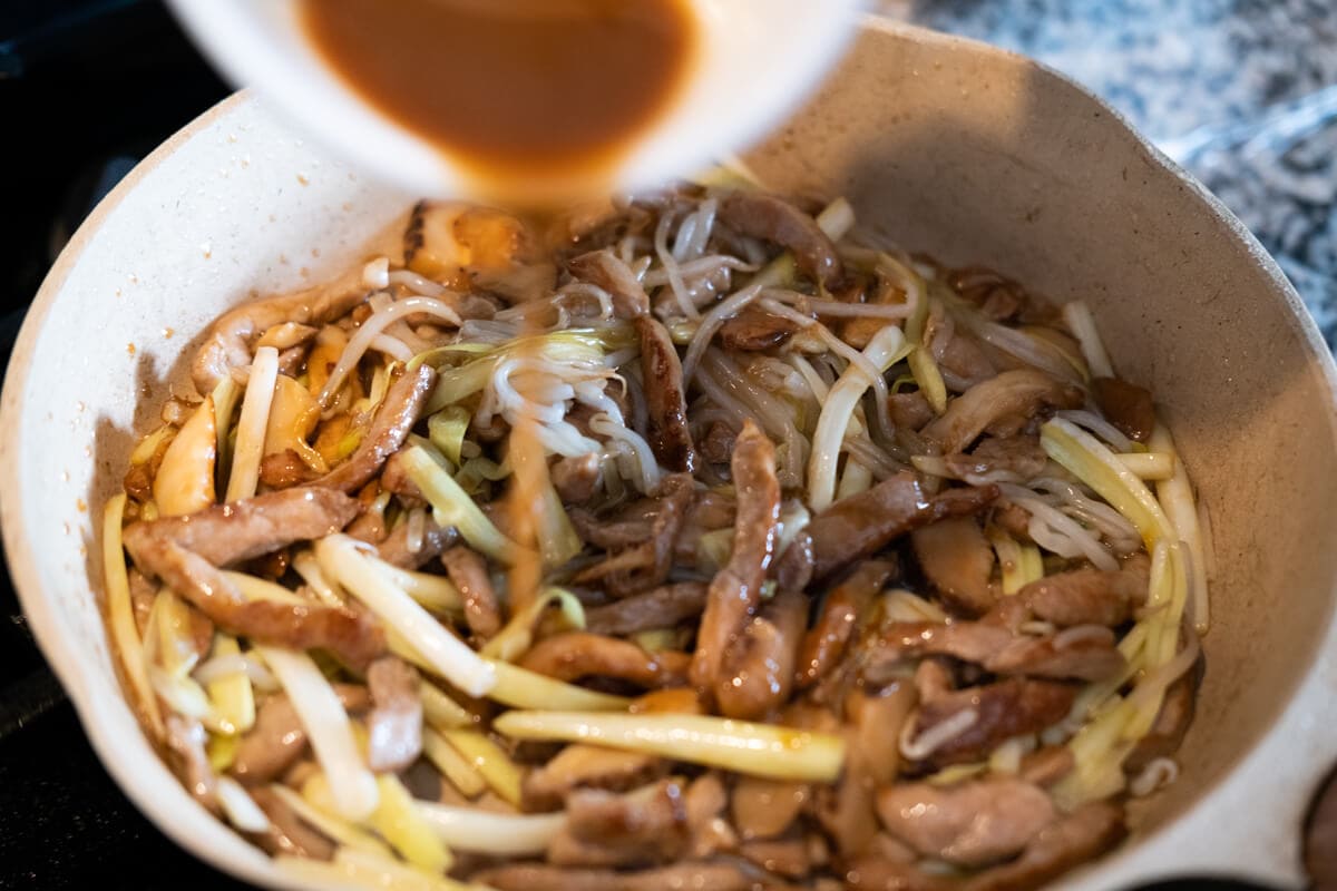 Add the chow mein sauce to the skillet with the pork, mushrooms, and vegetables.