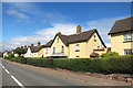 SX9897 : Yellow Houses in Broadclyst by Des Blenkinsopp