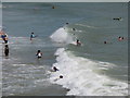 SZ1191 : Surfers and swimmers by Boscombe Pier by David Hawgood