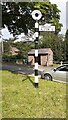 NY5738 : Finger signpost  on grass island and bus shelter in Glassonby by Roger Templeman