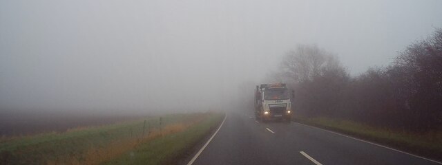 A skip lorry looms