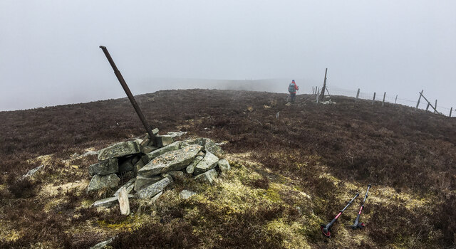 Hill walker leaving summit cairn of Blath Bhalg