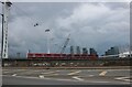 TQ3980 : DLR train going under the cable car, Silvertown by David Howard