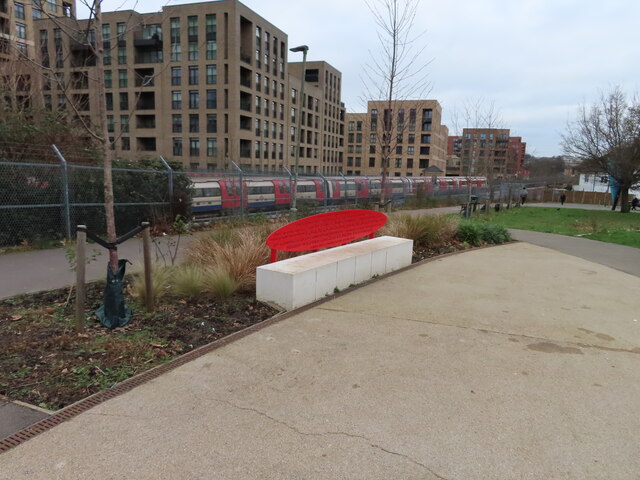 Bench in Colindale Park, tube train beyond