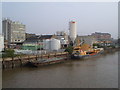 TQ2575 : Thames wharves from Wandsworth Bridge by Derek Harper