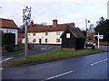 TM3973 : The Queens Head Public House & Village Sign by Geographer