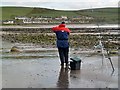 NX0941 : A sea angler at Port Logan Bay by Walter Baxter