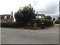 TL9769 : Stock Hill Postbox & Roadsign by Geographer