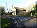 SO3357 : A barn and timber stacks by Philip Halling