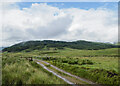 NN8151 : Hill road with gate near to Ruith Mhuilinn by Trevor Littlewood