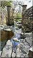 SD9390 : Grange Beck flowing though the piers of dismantled Wensleydale Railway by Roger Templeman