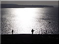 SW8575 : Trevose Head: silhouetted walkers on the coast path by Chris Downer