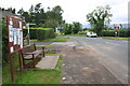 NY6818 : Noticeboard and bench beside main road through Burrells by Roger Templeman