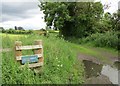 NS7748 : Signpost and overgrown stile at Hailstonemyre by Alan O'Dowd