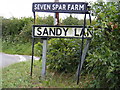 TM2557 : Sandy Lane & Seven Stars Farm signs by Geographer