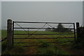 SO6422 : View through a gate: infilled railway cutting at Ryeford by John Winder