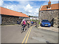 NU2519 : Cyclists through Craster by Stephen Craven