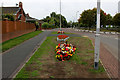 SE4133 : Small Floral Display on the A642, North East Garforth by Chris Heaton