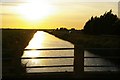 TL3588 : Looking west into the sunset along Forty Foot Drain, at Puddock Bridge by Christopher Hilton