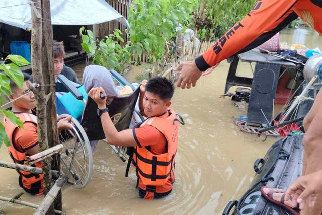 <p>Philippine coast guard rescuers carry out people trapped in their homes after Trami caused flooding in Libon village of Albay province on 23 October 2024 </p>