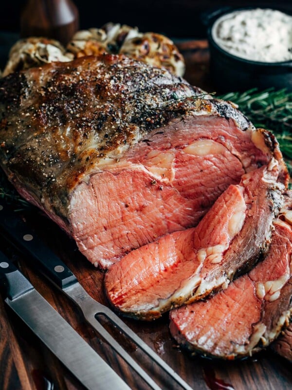 partially sliced slow roasted prime rib on a carving board