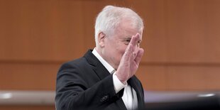 Seehofer grüßt mit erhobener Hand