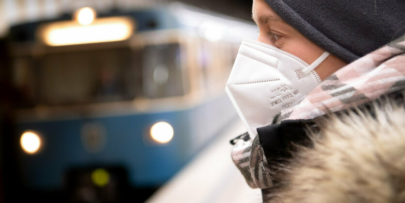 Ein Frau mit FFP2-Maske wartet in einer U-Bahnstation auf die Bahn