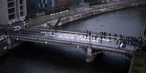 Aktivisten von Fridays For Future stehen auf einer Brücke und auf der Brücke steht: „Unsere Welt brennt, nutzt eure Stimme