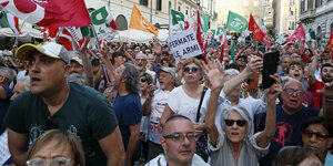 Eine Demonstration mit Fahnen und Transparenten in einer Straße