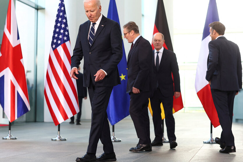 Biden , Scholz, Starmer und Macron gehen zwischen Flaggen