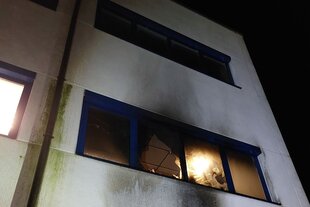 Feuer hinter einem eingeworfenen Fenster von Opto Precision