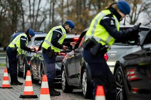 Beamte der niederländischen Staatspolizei überprüfen an der Grenze zu Belgien am ersten Tag der Grenzkontrollen Autofahrer