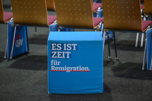 Ein Sitzhocker mit der Aufschrift "Es ist Zeit für Remigration" steht in der Uckerseehalle zum Landesparteitag der AfD Brandenburg.