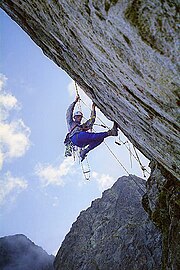 An aid climber hanging from the rock face