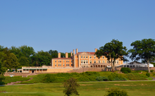 A three-story beige Renaissance Revival mansion