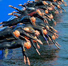 Plongeon d'un ponton de triathlète au départ.