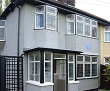 A gray two-story building, with numerous windows visible on both levels