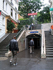 La rue vue depuis la rue Lamarck avec l'entrée de la station de métro.