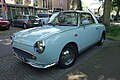 Voorzijde van een babyblauwe Nissan Figaro