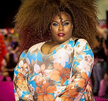 Photograph of a drag performer wearing an outfit with a floral print