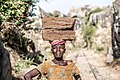 Woman of Tanzania carrying bricks on her head