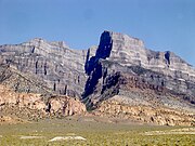 Pink monzonite laccolith intrudes within the grey Cambrian and Ordovician strata near Notch Peak, Utah[32]