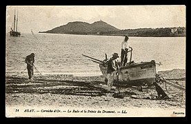 Carte postale noir et blanc. Barque sur la grève avec un deux mâts dans une baie bordée de montagnes.