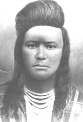 Portait d'un jeune Amérindien avec les cheveux au-dessus du front enroulés vers l'arrière.