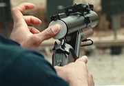 Photographie d'un homme en train de recharger un lance-grenades.