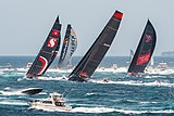 black and red boats in the middle of the waves of the blue sea