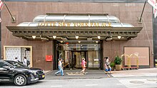 Entrance of the hotel from 51st Street, with cars in front