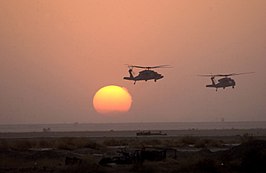 HH-60 Blackhawk-legerhelikopters vliegen voorbij de ondergaande zon op 2 april 2003 naar een vooruitgeschoven locatie in Zuid-Irak tijdens Operatie Iraqi Freedom.