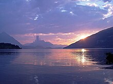 Lac au milieu des montagnes et une ville au loin.